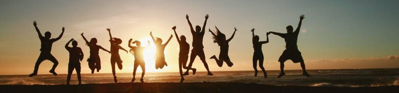GRIWA GROUP | Gemeinsam Hochspringende Menschengruppe bei Sonnenuntergang